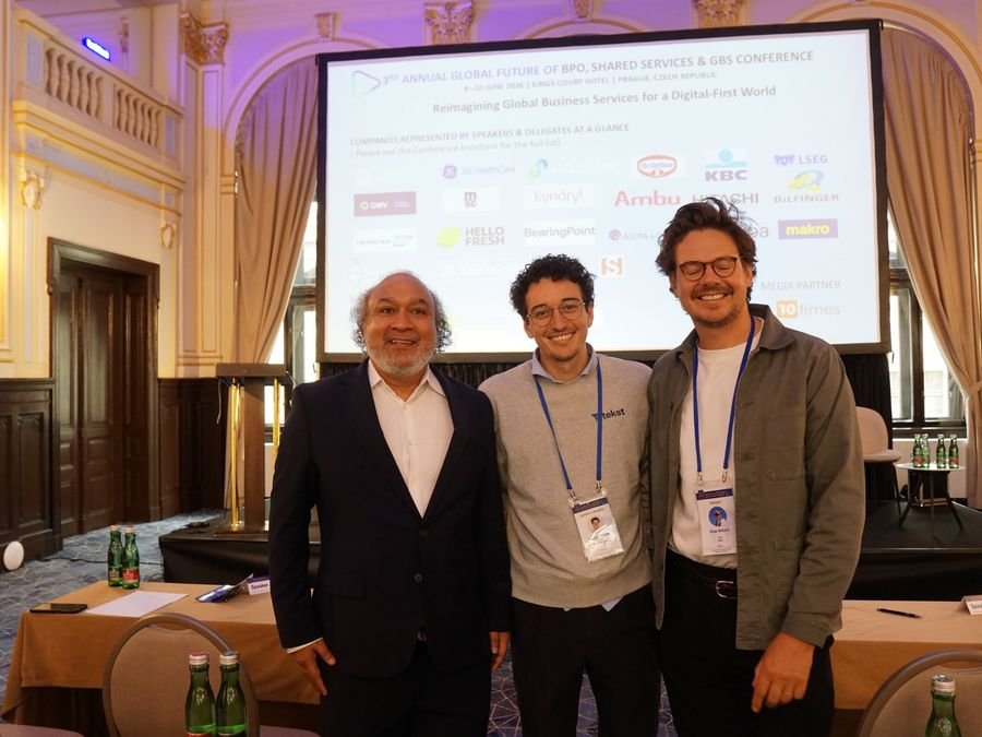 Three delegates in front of the conference screen at Hotel KINGS COURT, Prague, 2026 edition of the Global Future of BPO, Shared Services & GBS Conference